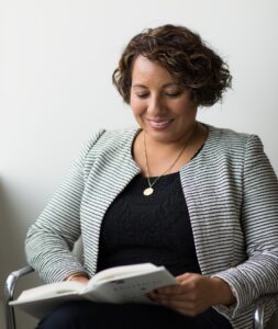 smiling woman sitting and reading book